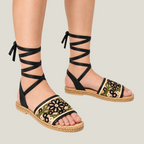 Fiorella black floral lace-up sandals styled on feet